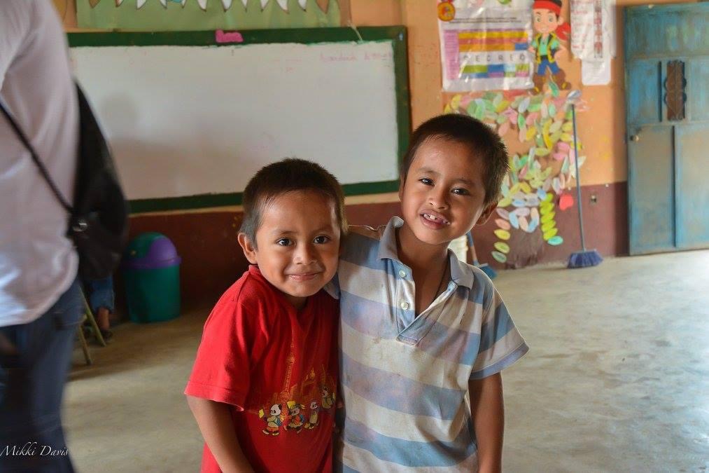 Mateo and a friend smiling in their classroom in rural Central America