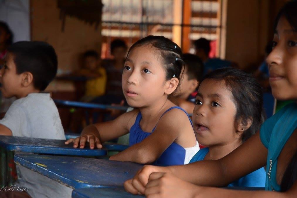 Children learning together at their desks in a rural Central American classroom